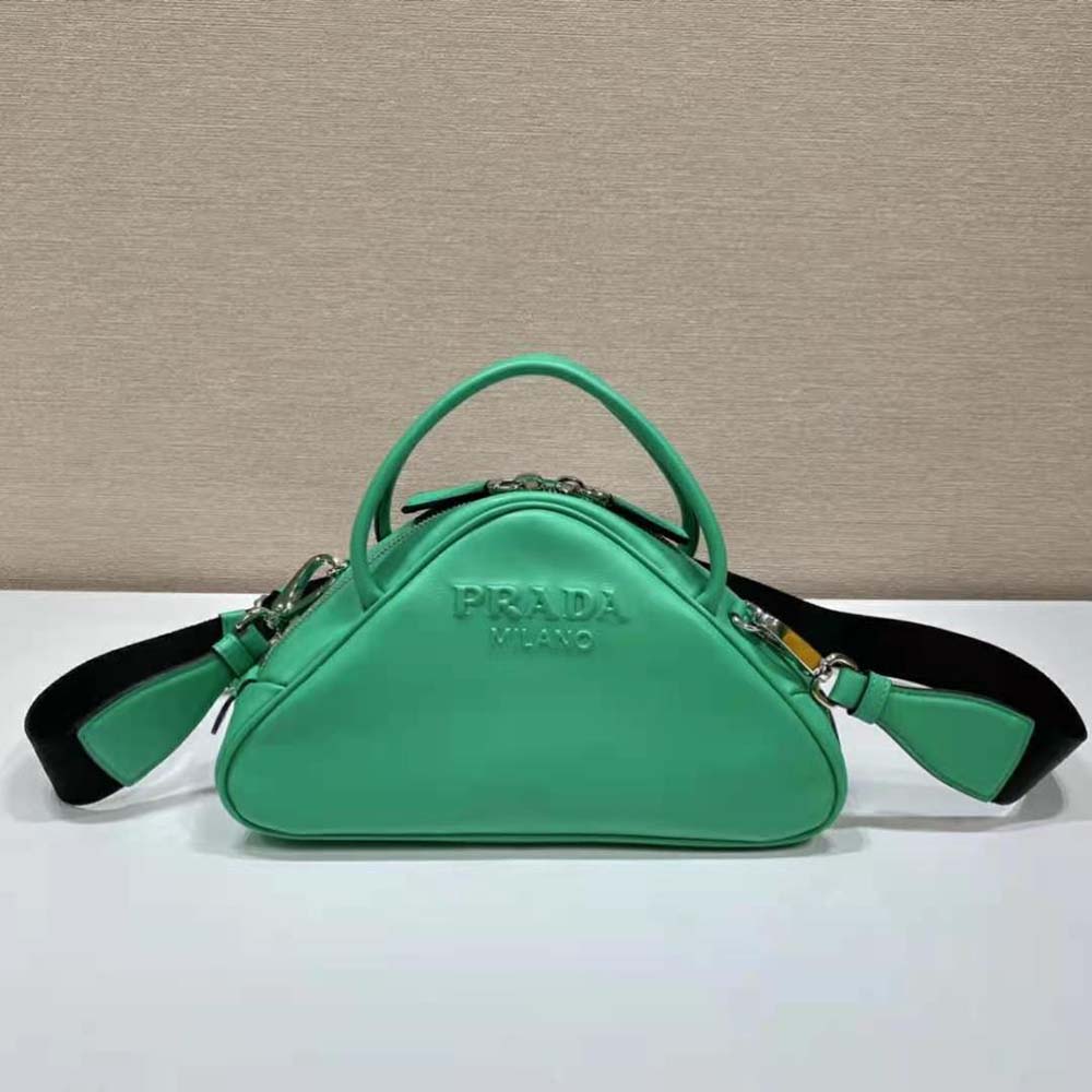 Close-up of green leather texture and silver Prada triangle logo hardware