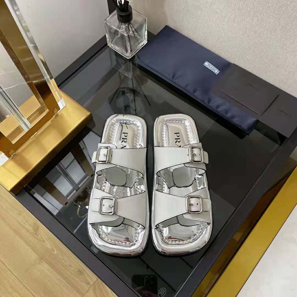 Close-up view of silver leather and metal buckle detail on Prada sandals