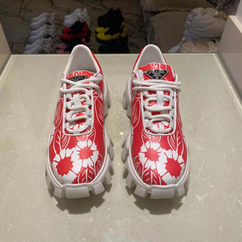 Close-up of red nylon material and Prada logo on sneakers