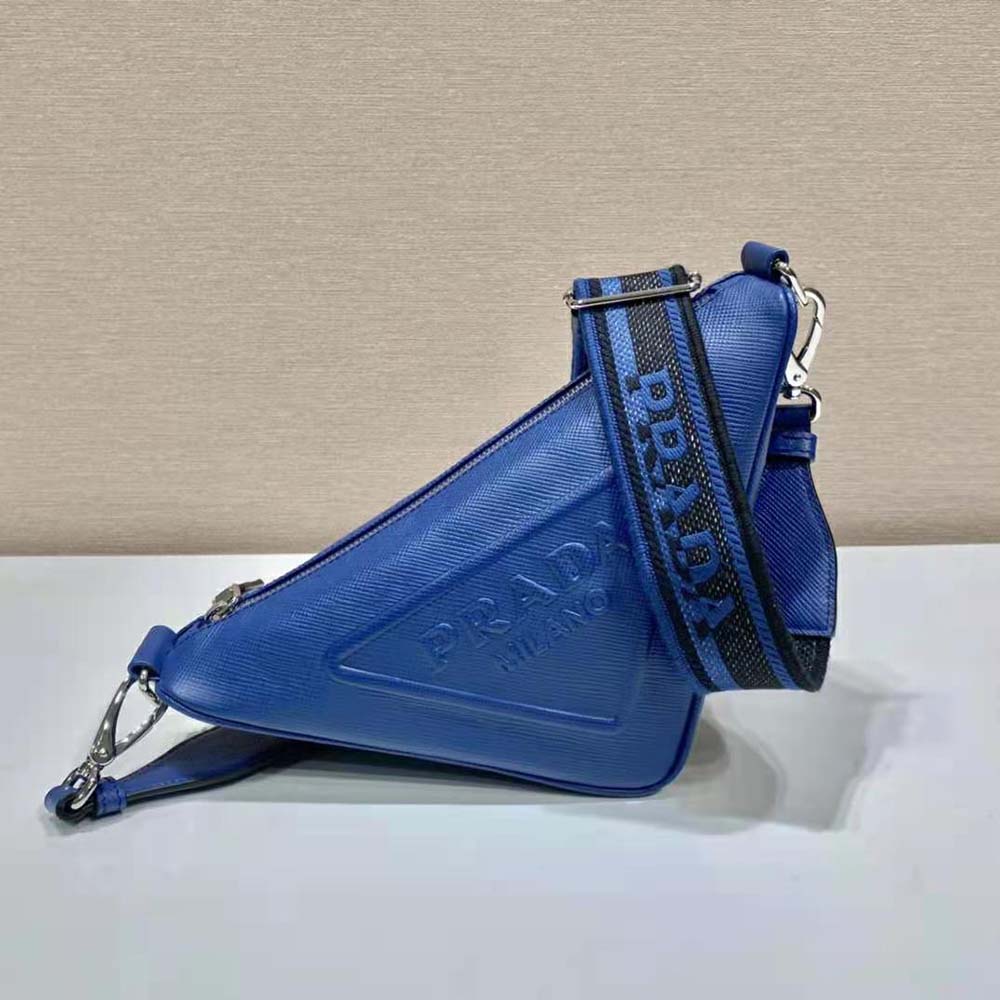 Close-up on silver Prada triangle logo detail on navy bag