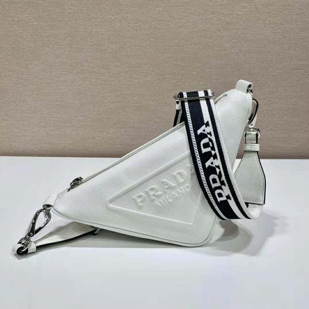 Close-up detail of silver Prada triangle plaque on white Saffiano leather bag
