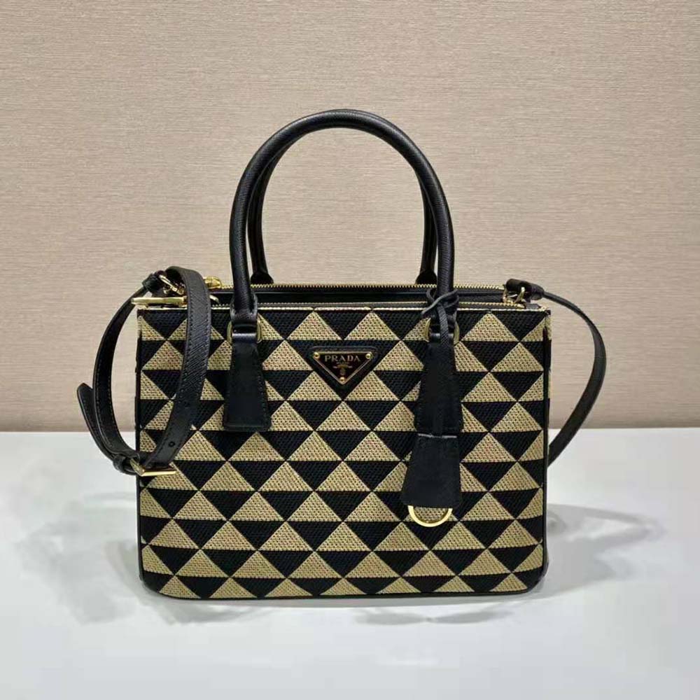 Close-up on gold-tone Prada logo hardware on brown jacquard bag