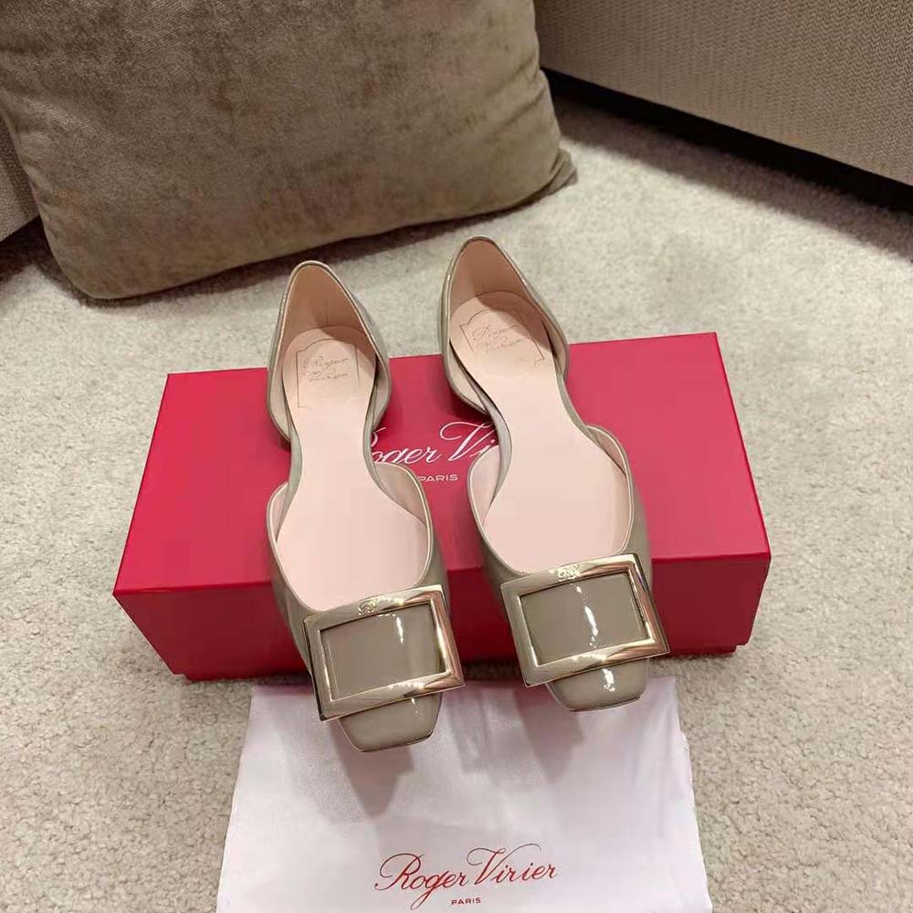 Close-up of silver metal buckle on Roger Vivier patent leather ballerinas