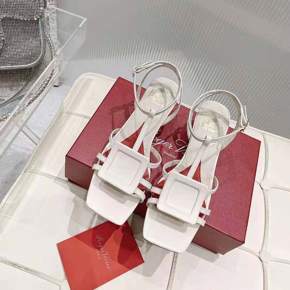 Close-up of Virgule covered buckle detail on white leather sandal