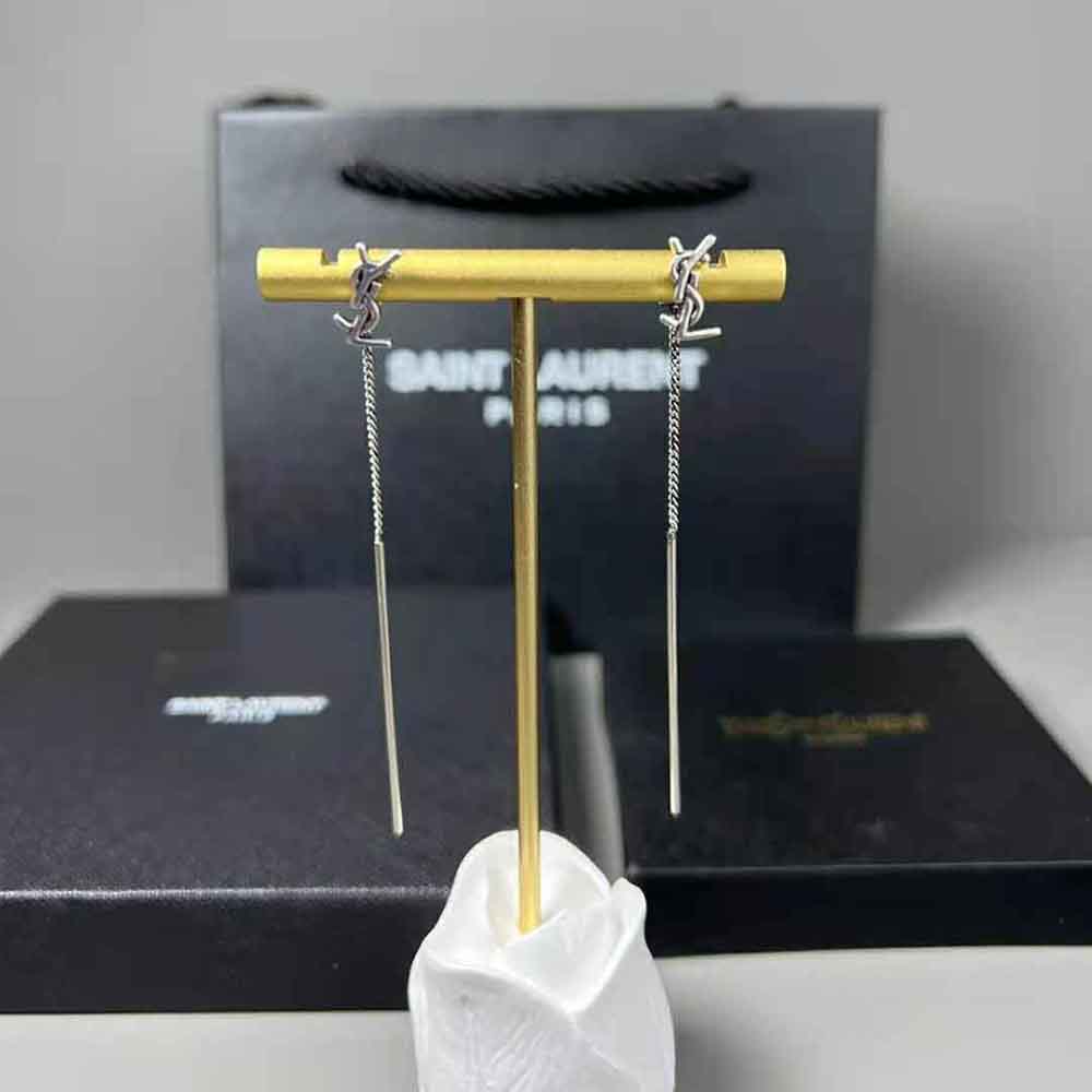 Close-up detail of YSL logo on silver threader earrings by Saint Laurent