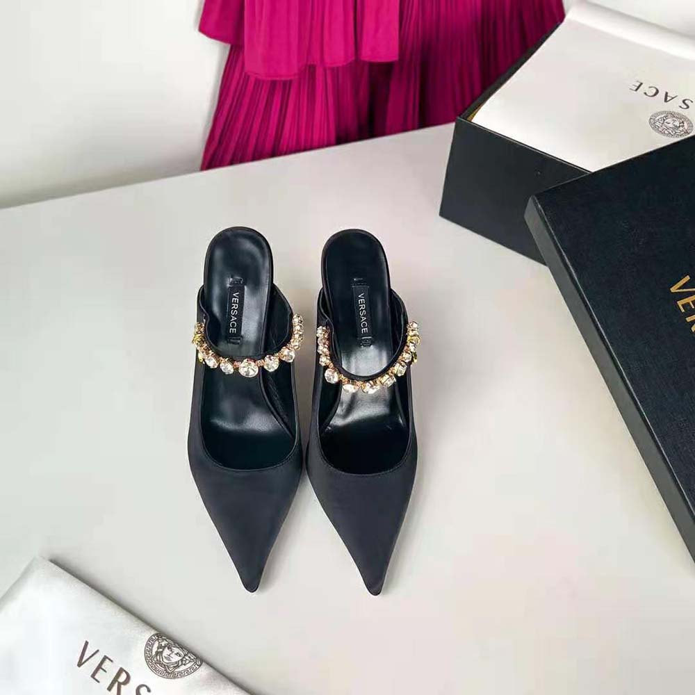 Close-up on gold Medusa emblem on Versace Women Artifact Mules in Black