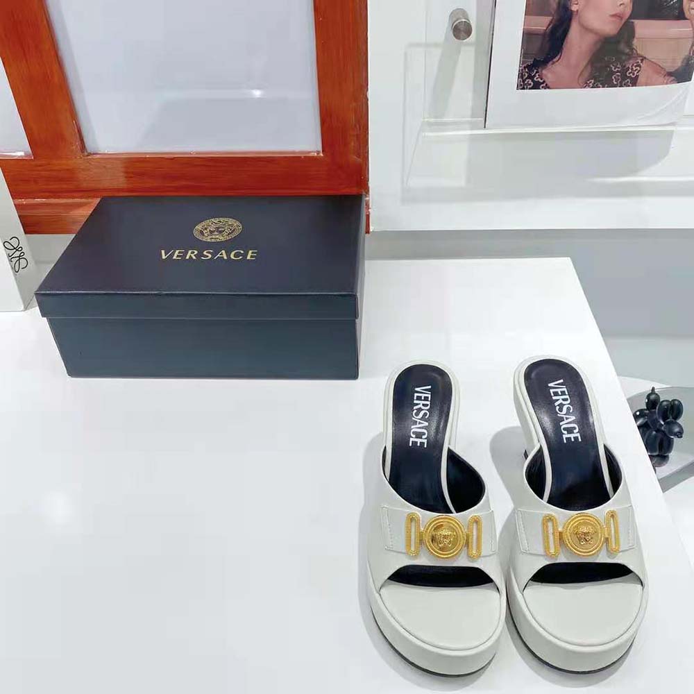 Close-up of gold Medusa hardware on Versace Women Medusa Biggie Mules