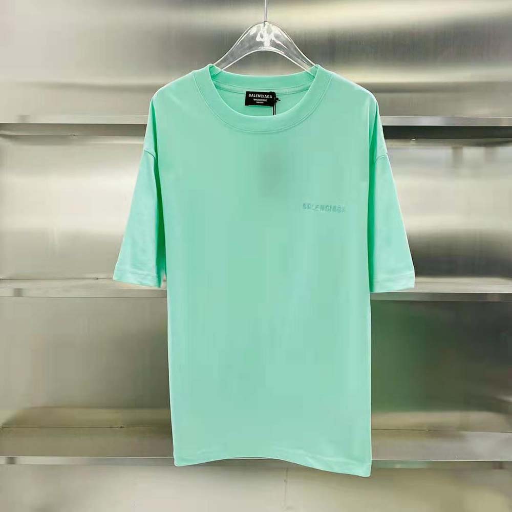 Close-up of Balenciaga logo detail on green medium fit T-shirt