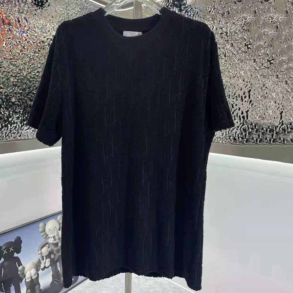 Close-up of Dior Oblique jacquard pattern on navy blue T-shirt fabric