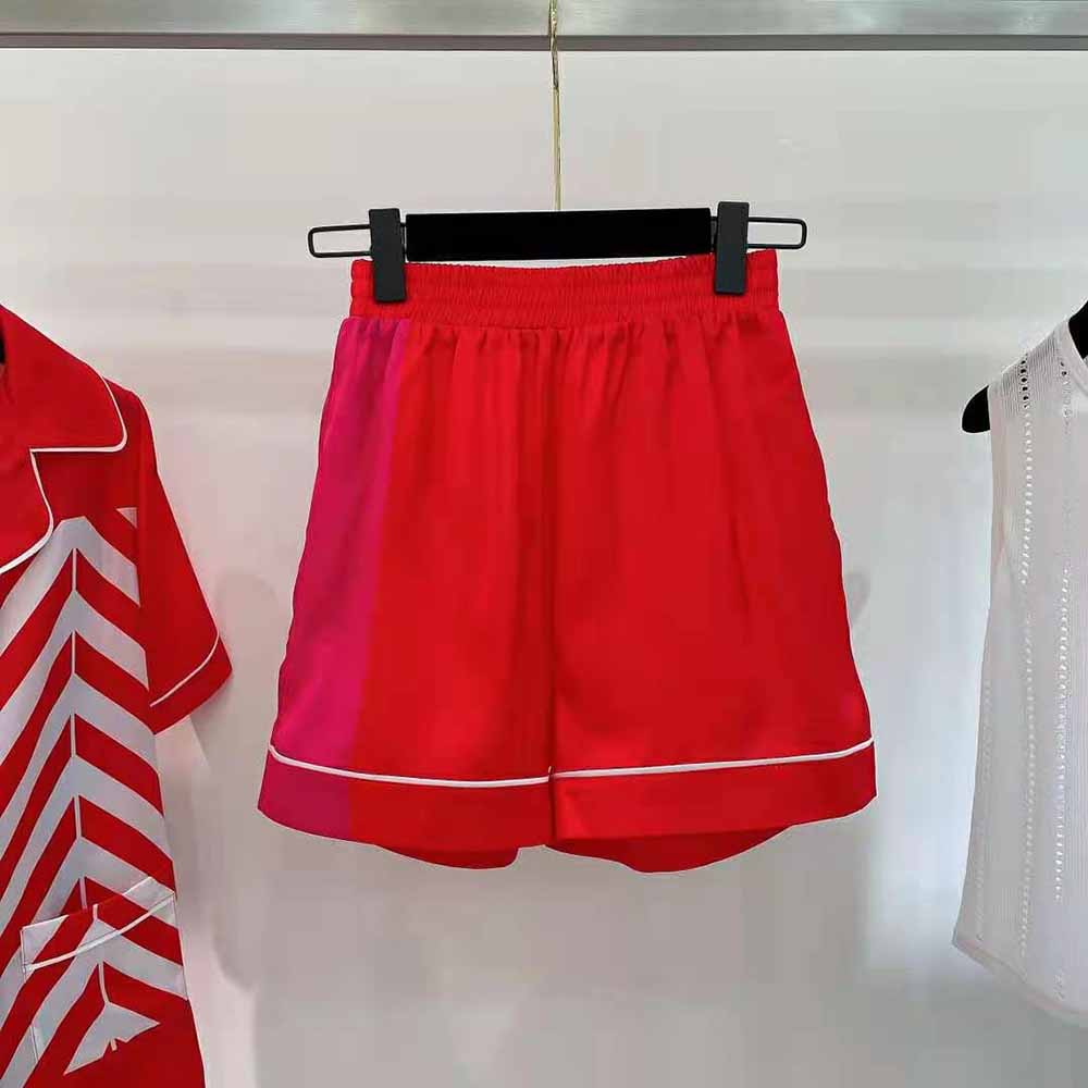 Close-up of tonal zipper and Dior logo hardware on bright pink shorts