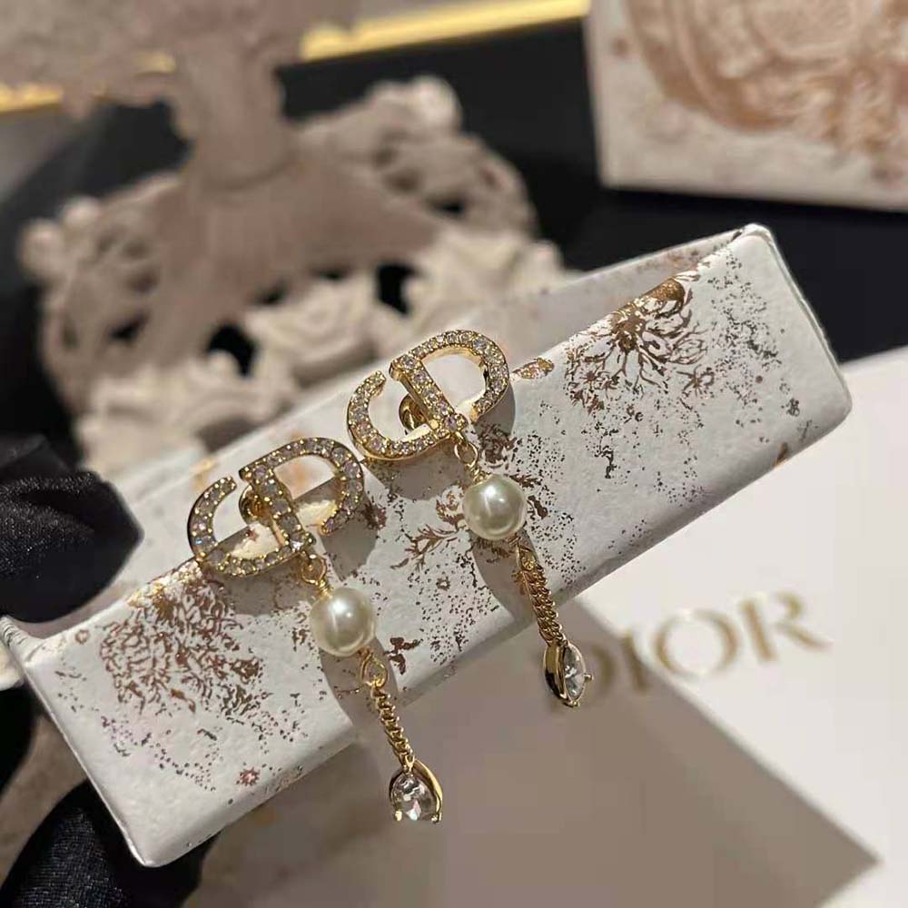 Side angle showing delicate silhouette of Dior Women Petit CD Earrings in gold