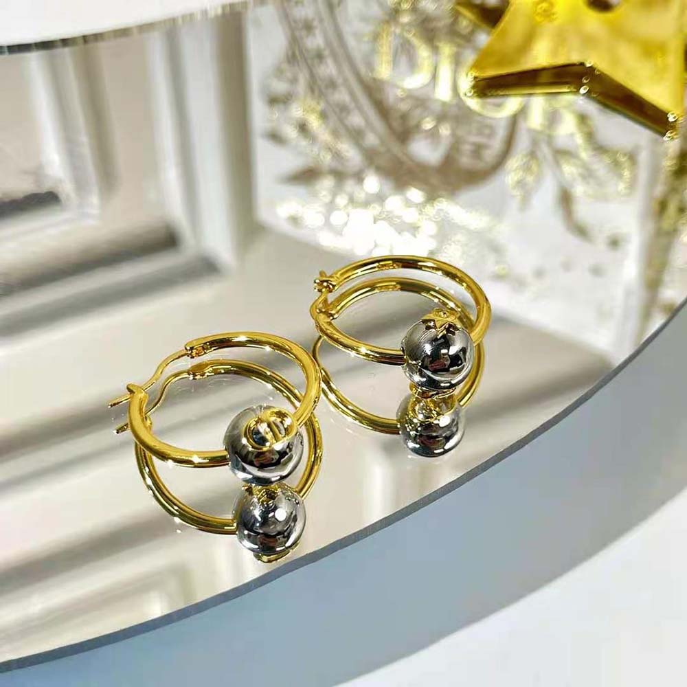 Side angle showcasing shine of Dior Women Petit CD Earrings in gold and palladium