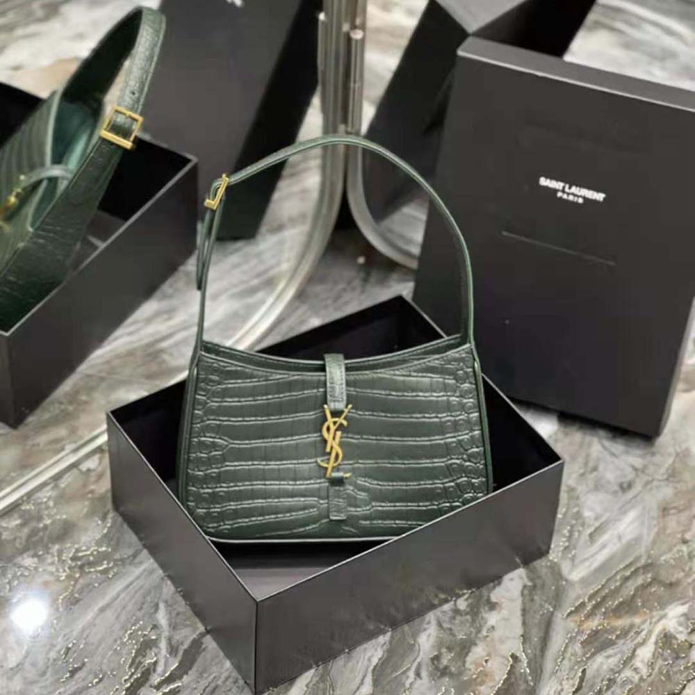 Close-up of gold YSL hardware detail on green crocodile-embossed leather hobo bag