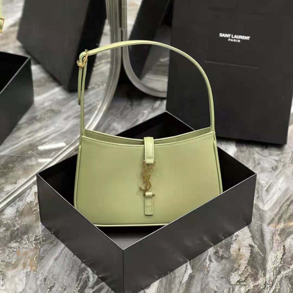 Close-up of gold YSL logo hardware on green smooth leather bag