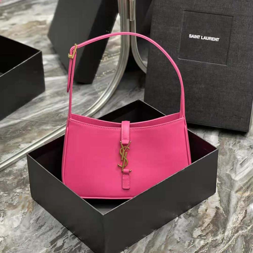 Close-up of gold-tone YSL logo hardware on smooth rose leather bag