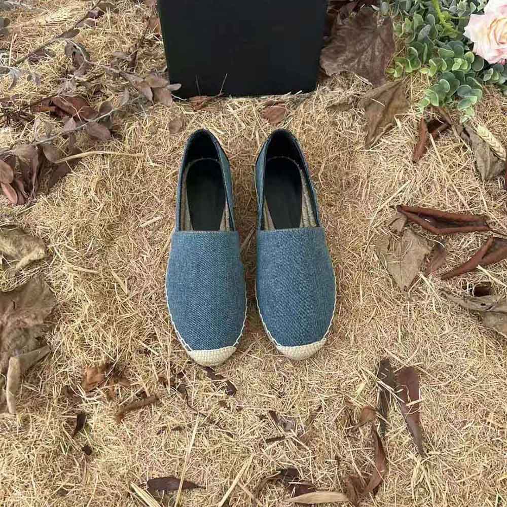 Close-up of embroidered YSL logo on denim navy espadrilles