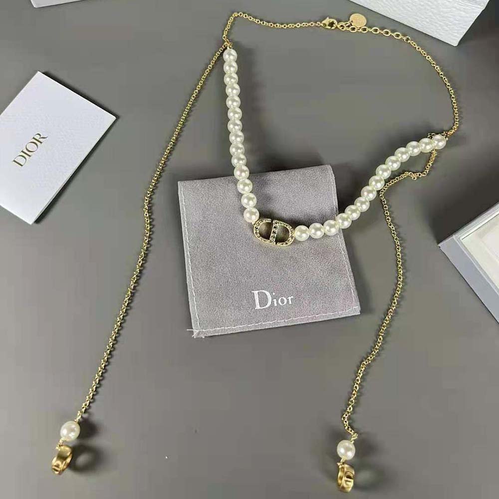 Close-up on white enamel and gold-finish CD logo charm necklace