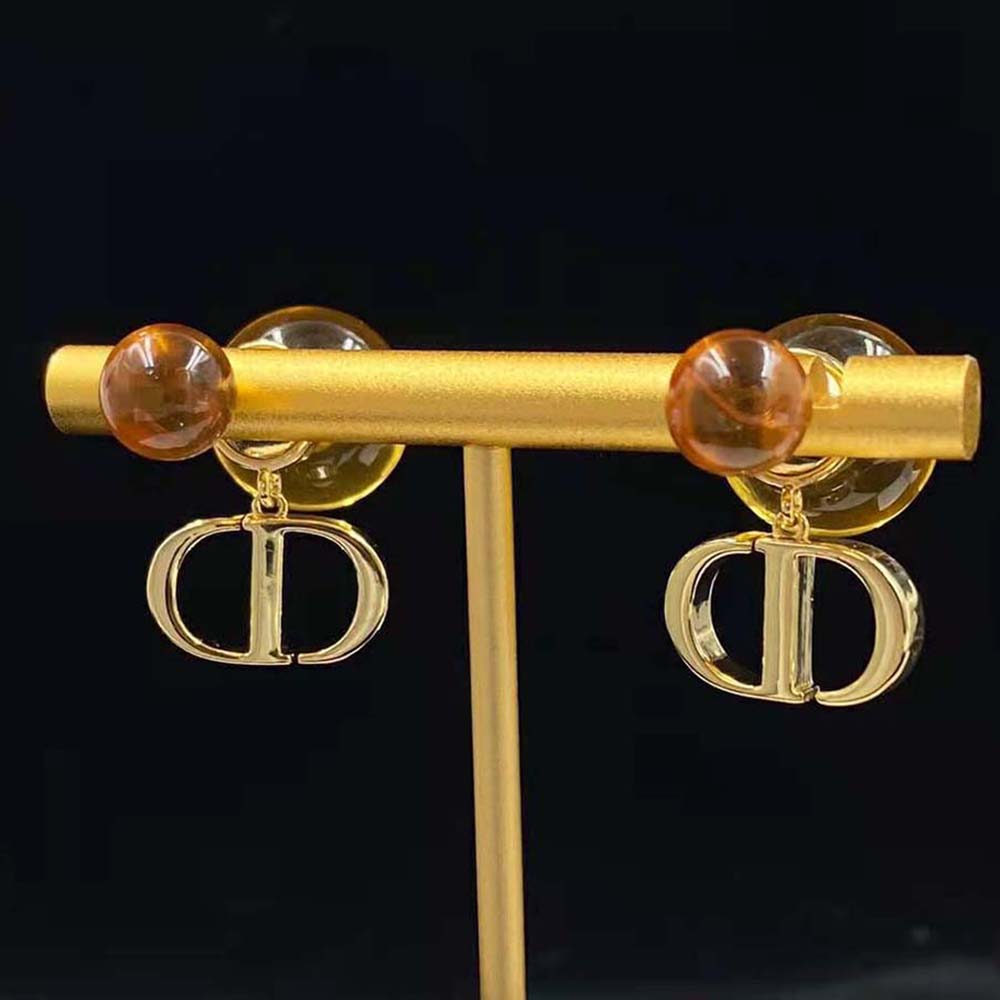 Close-up on fluorescent orange resin pearls of Dior Women Tribales Earrings