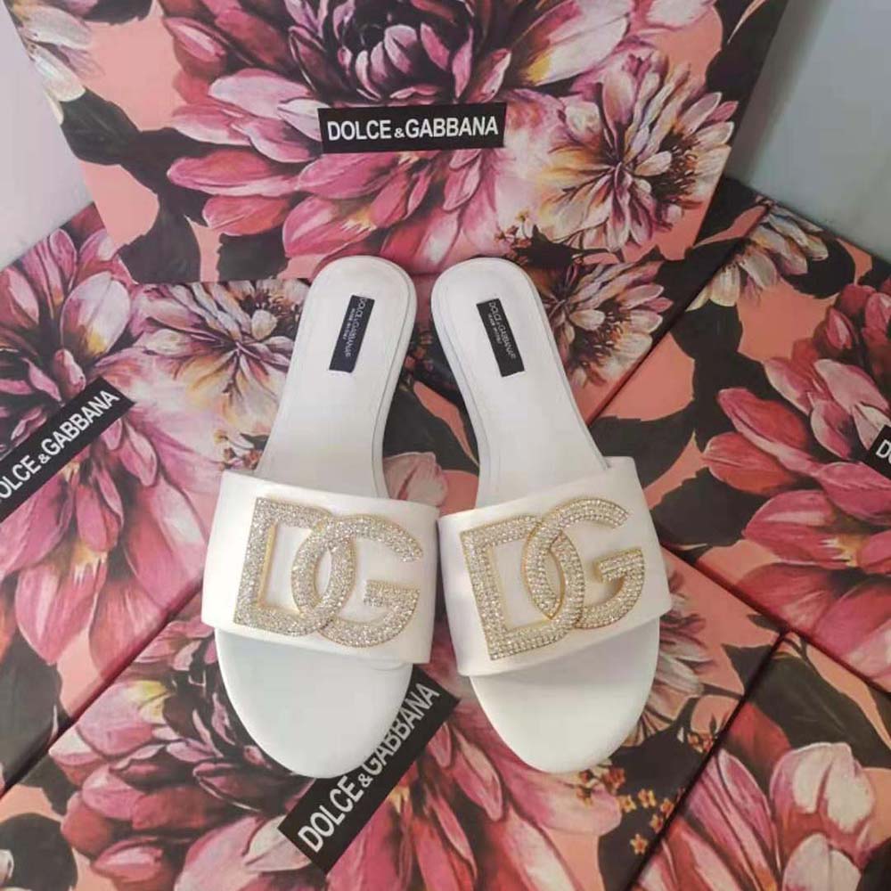 Close-up detail of DG logo hardware on white calfskin slides