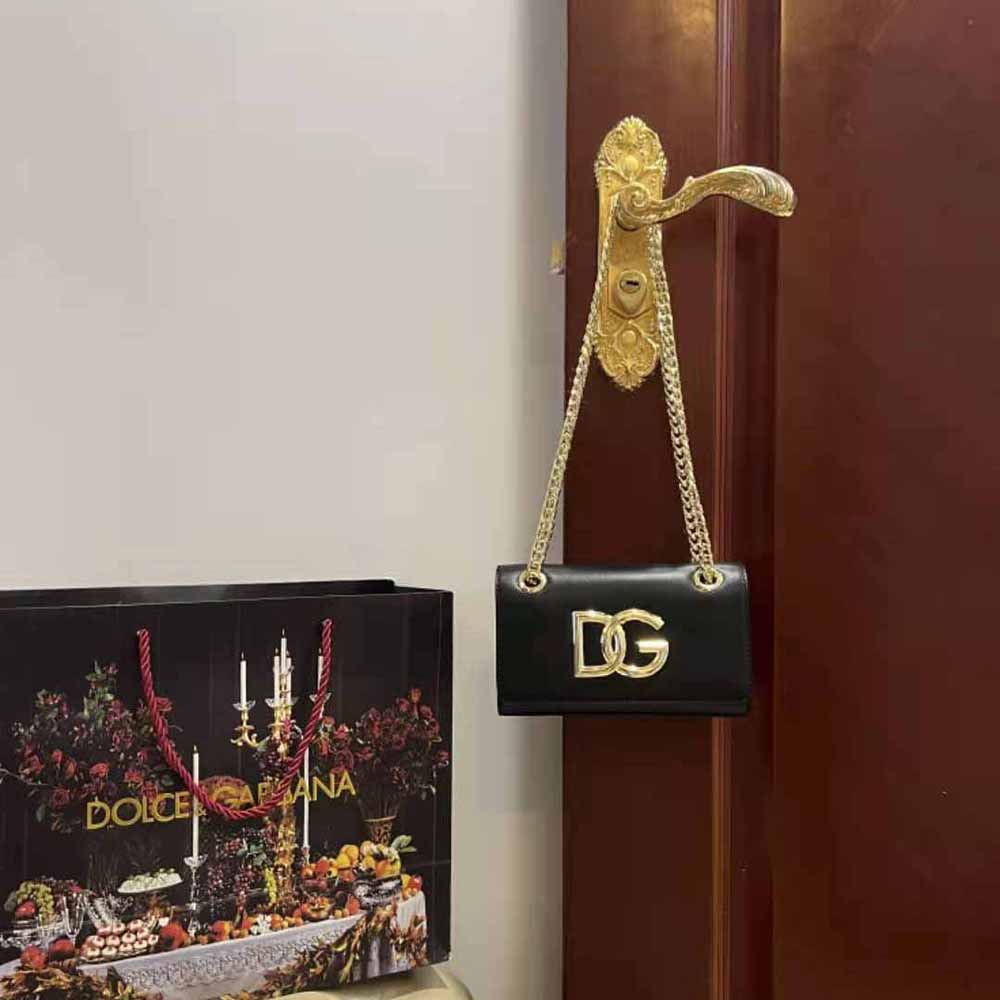 Close-up of gold-tone D&G logo hardware on black phone bag