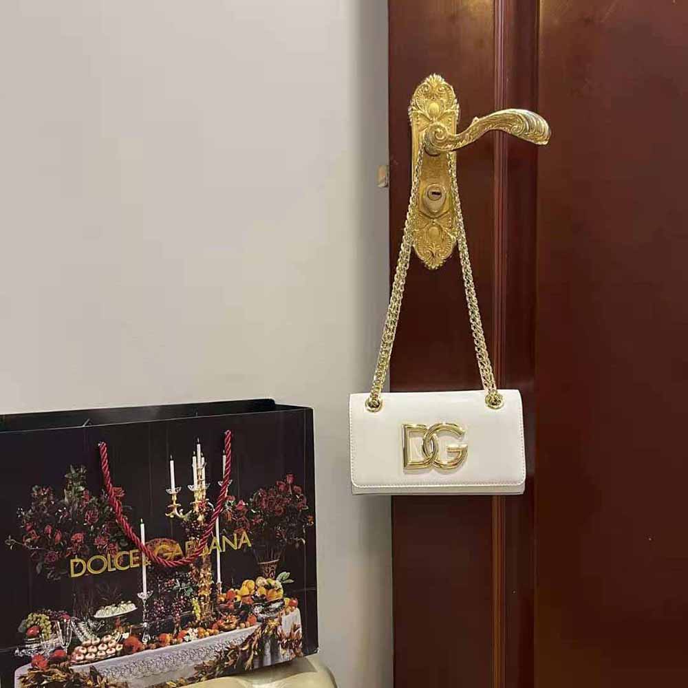 Close-up of silver-tone D&G logo hardware on polished calfskin phone bag