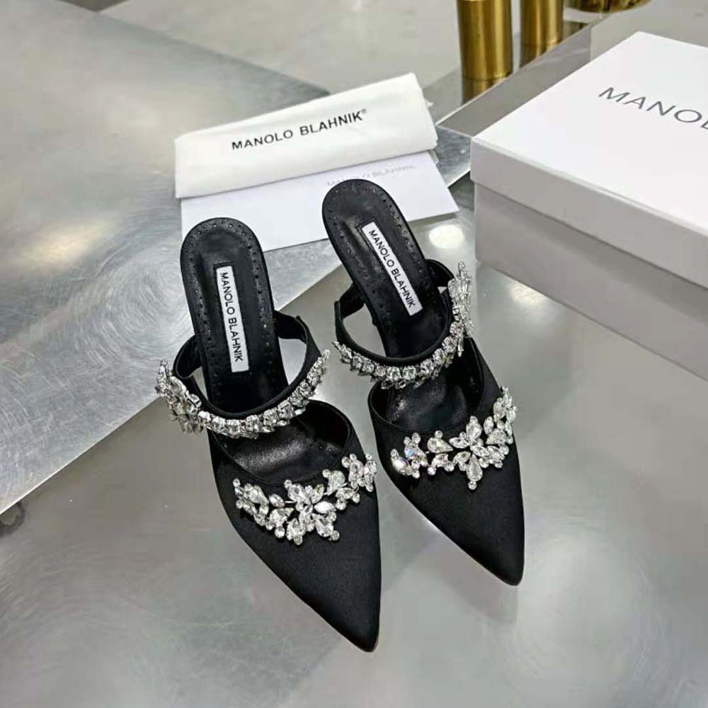 Close-up on crystal embellishments of Manolo Blahnik black satin mules