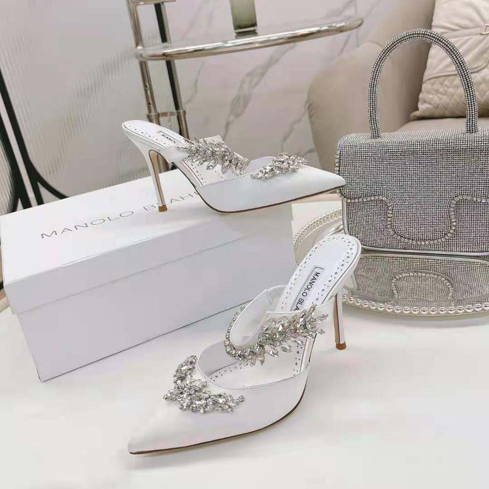 Close-up on crystal embellishments of Manolo Blahnik white satin mules