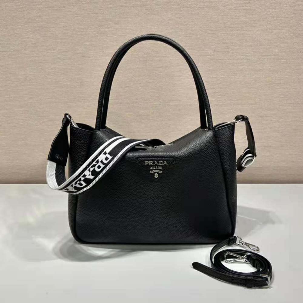 Close-up of Prada metal lettering on black leather handbag