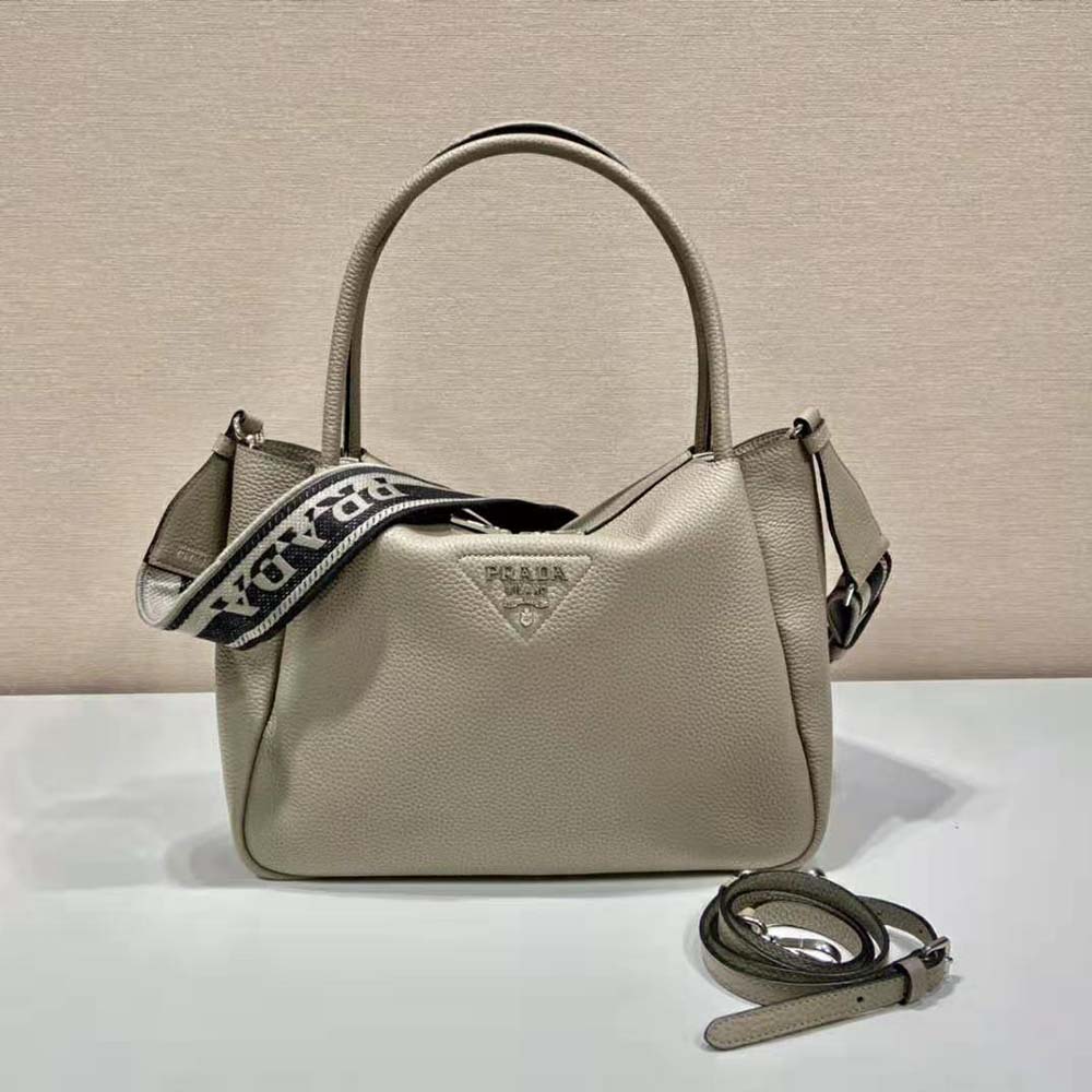 Close-up of Prada metal lettering logo on brown leather handbag