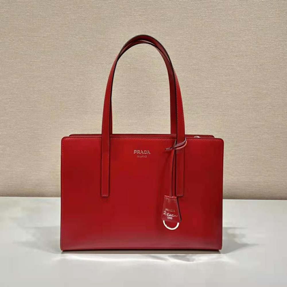 Close-up of silver-tone logo and brushed leather texture on Prada handbag