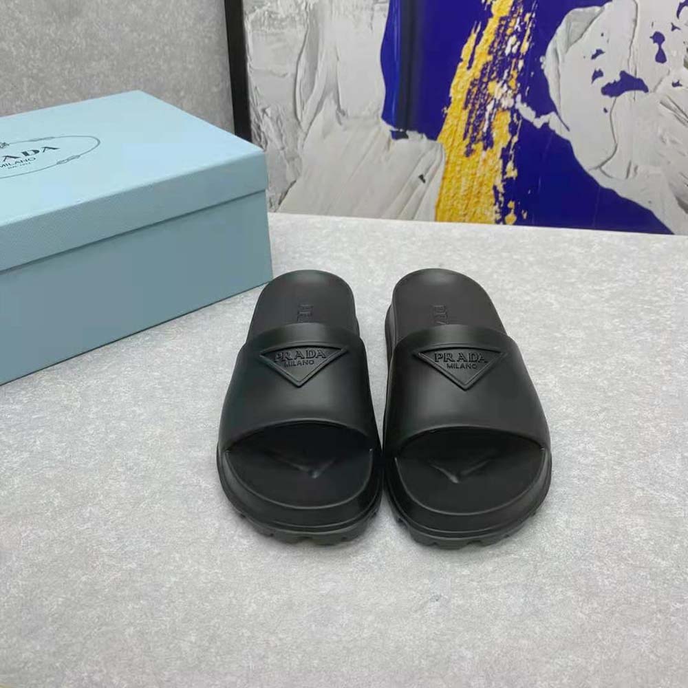 Close-up detail of embossed Prada logo on black rubber slide