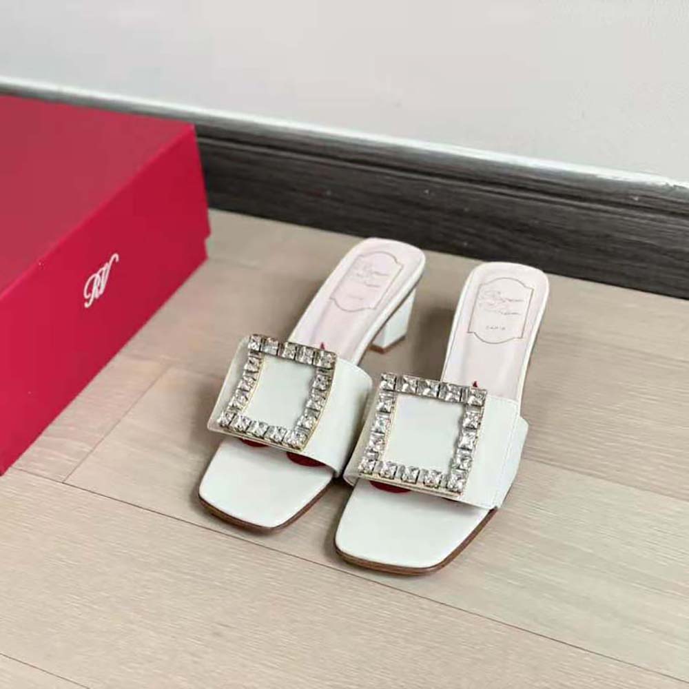 Close-up detail of crystal Love Strass buckle on Roger Vivier white mules
