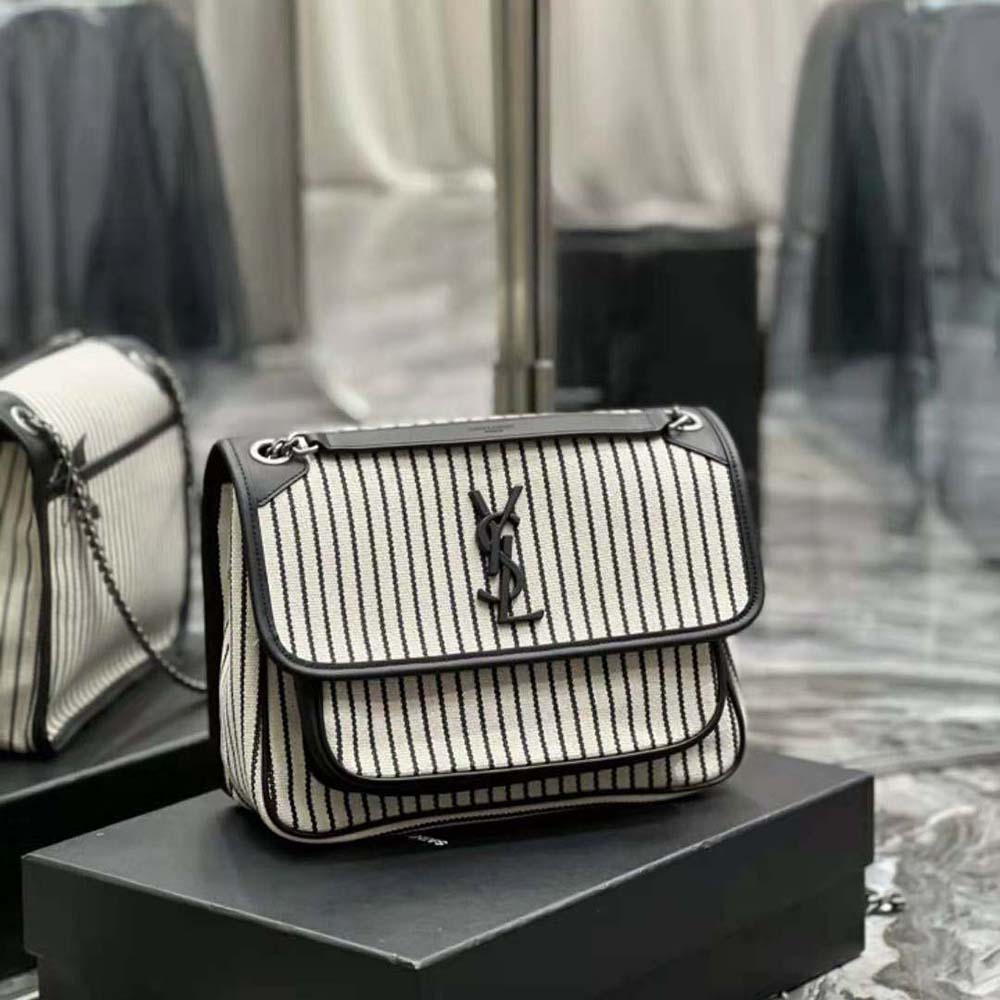 Side profile showing black leather flap and canvas texture of Saint Laurent YSL Niki Bag