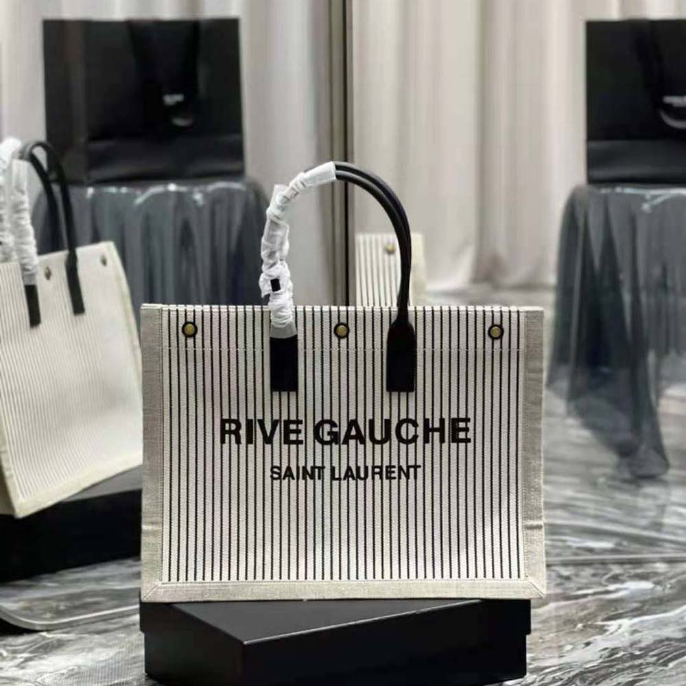 Close-up on gold YSL logo hardware on Saint Laurent YSL Women Rive Gauche Tote Bag