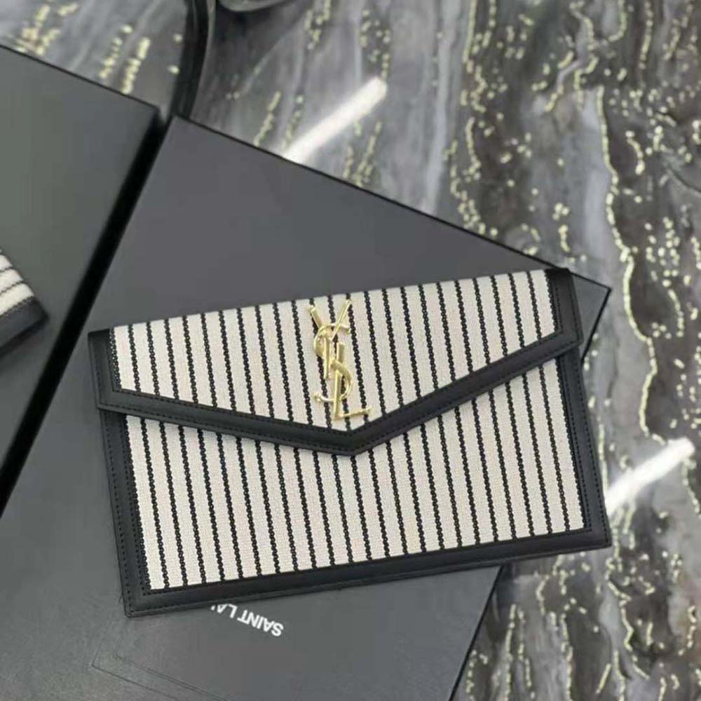 Close-up of gold YSL logo hardware on Uptown Pouch in black