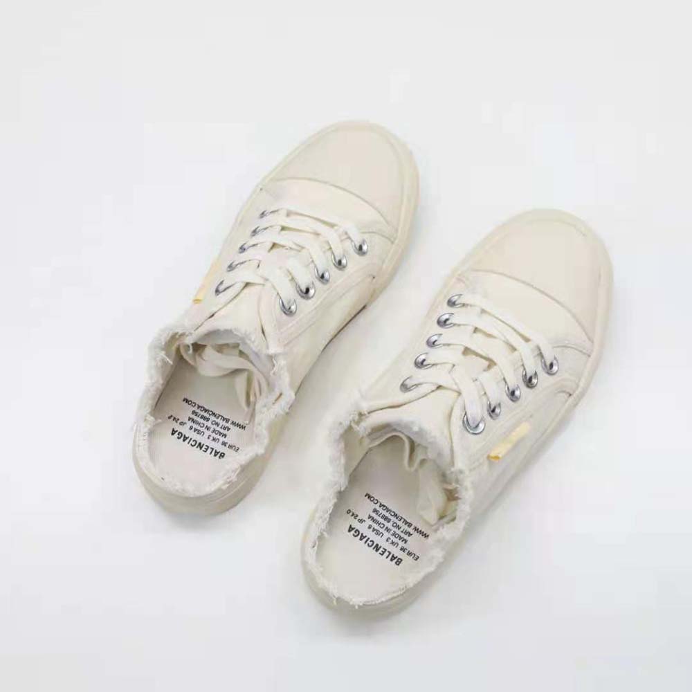 Close-up on embossed Balenciaga logo on the heel of white sneaker mule