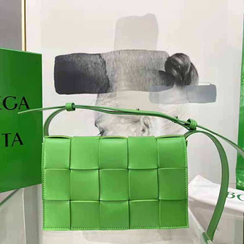 Close-up detail of intrecciato green leather texture on Bottega Veneta women’s cross-body bag