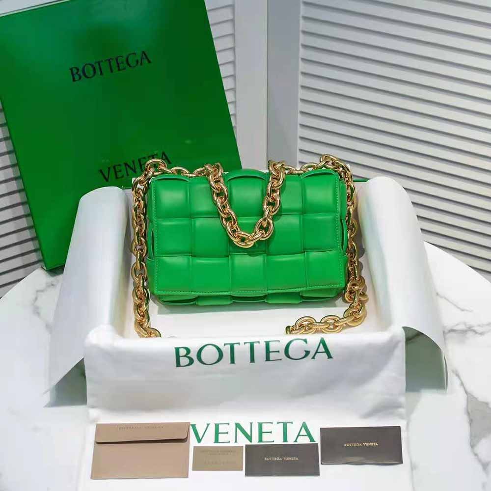 Close-up of green padded intrecciato leather and antique gold chain strap detail