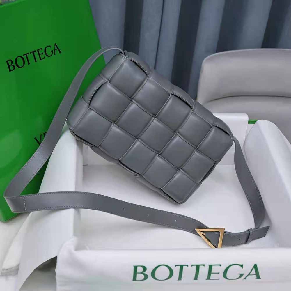 Side angle showing gold-tone hardware on Bottega Veneta gray leather bag