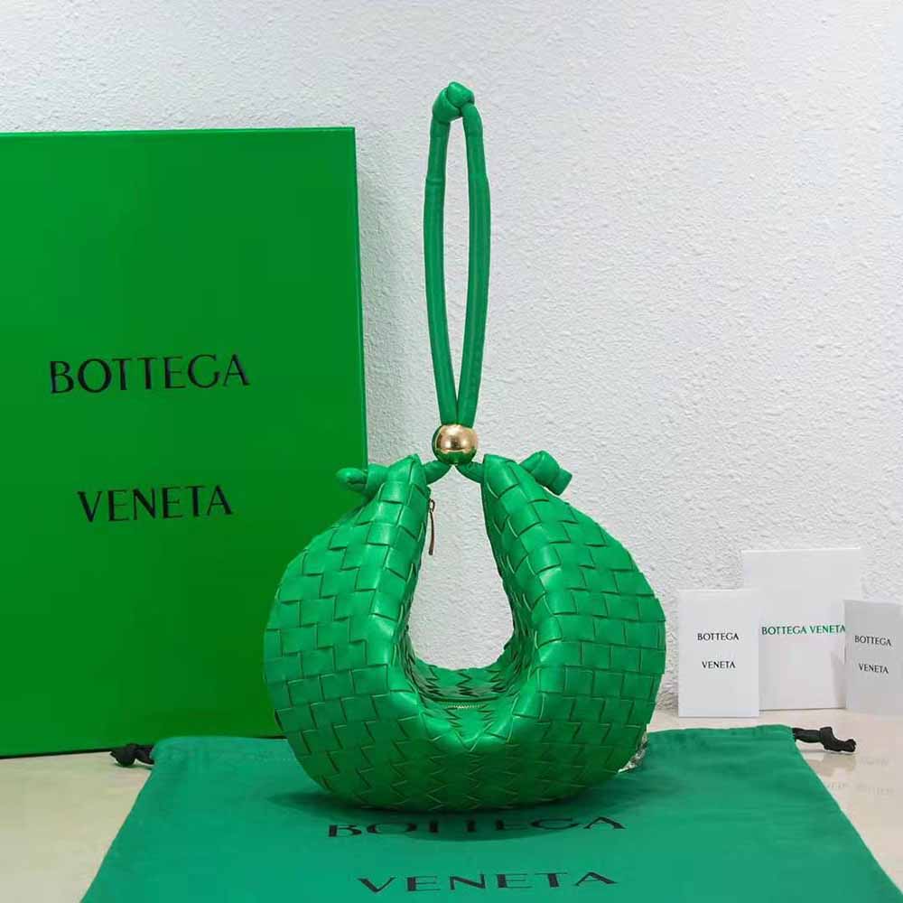 Close-up of green intrecciato leather and matte gold hardware on pouch