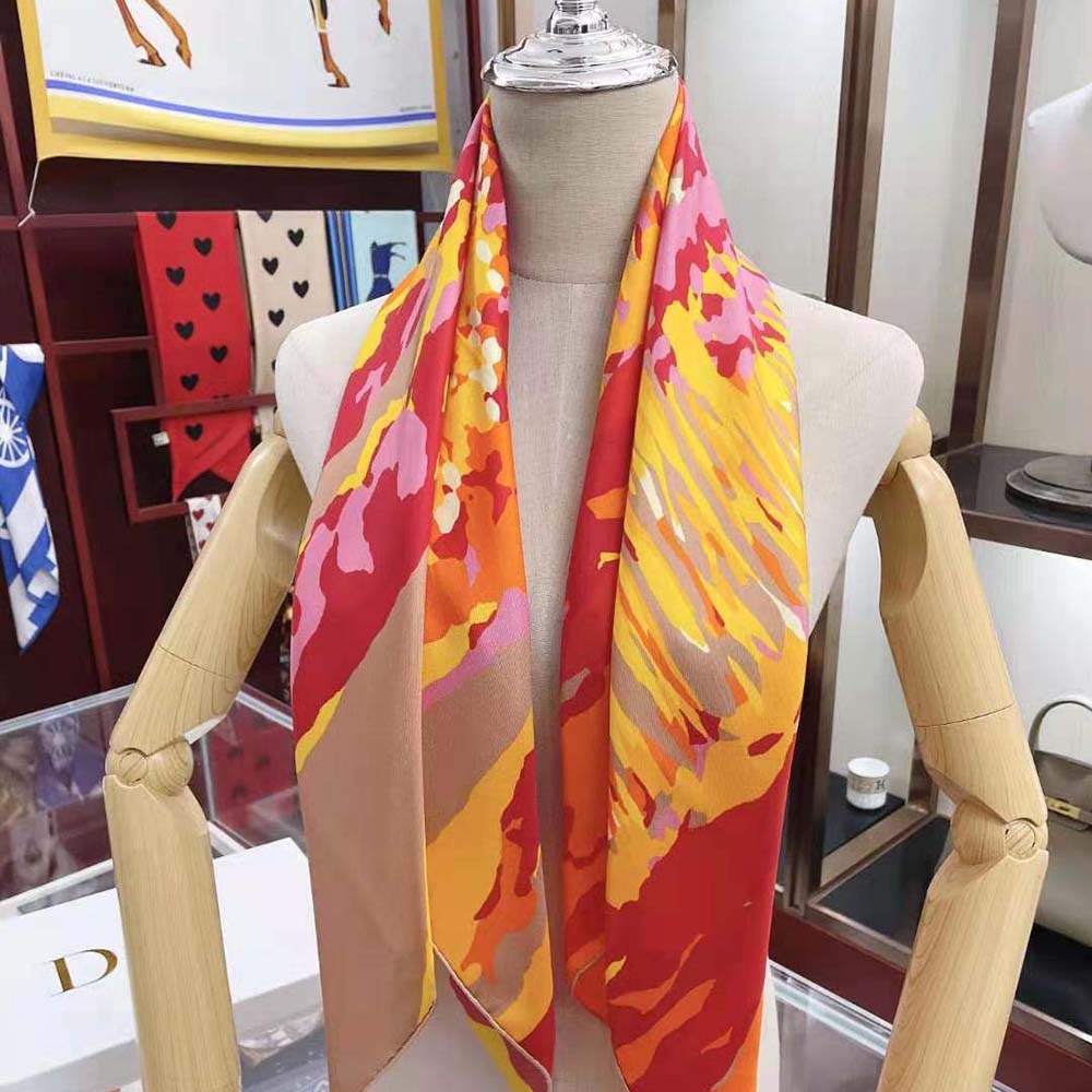 Close-up detail of orange and multicolor pattern on Dior scarf