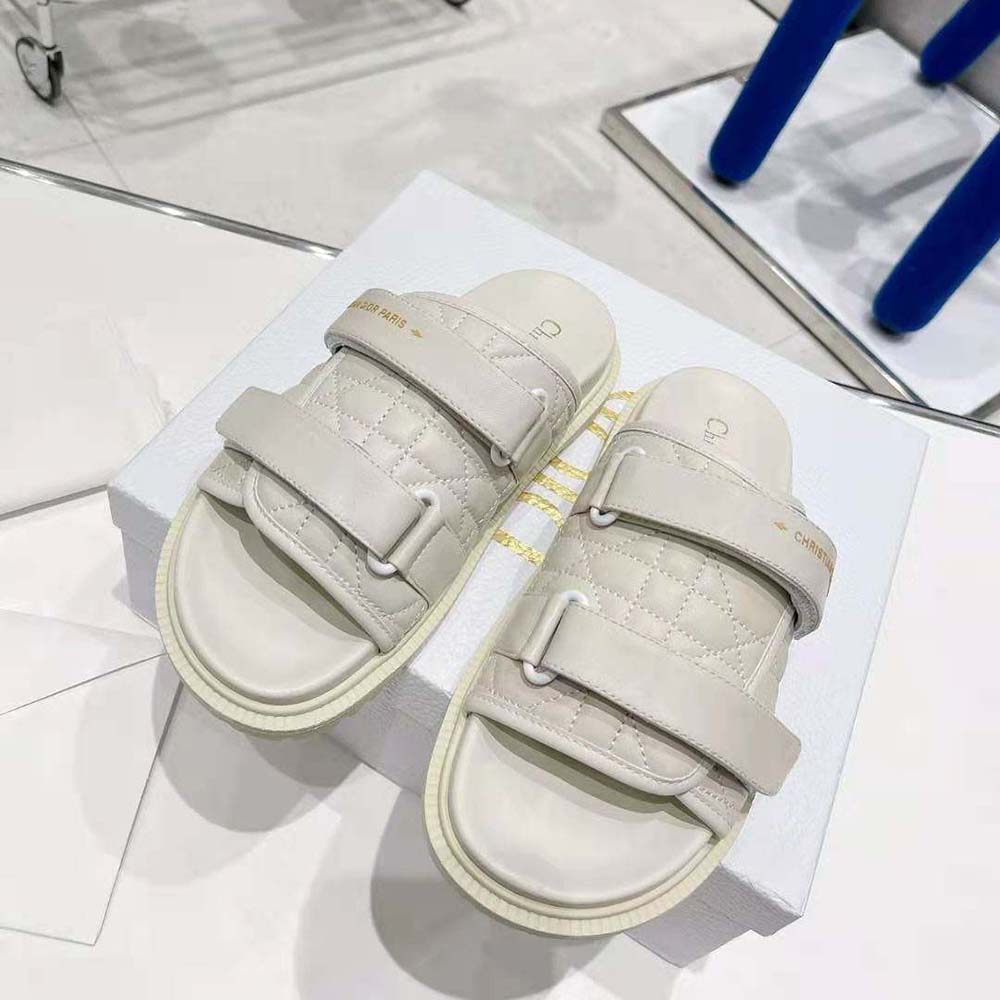 Close-up on silver Dior logo hardware on white quilted slide sandal