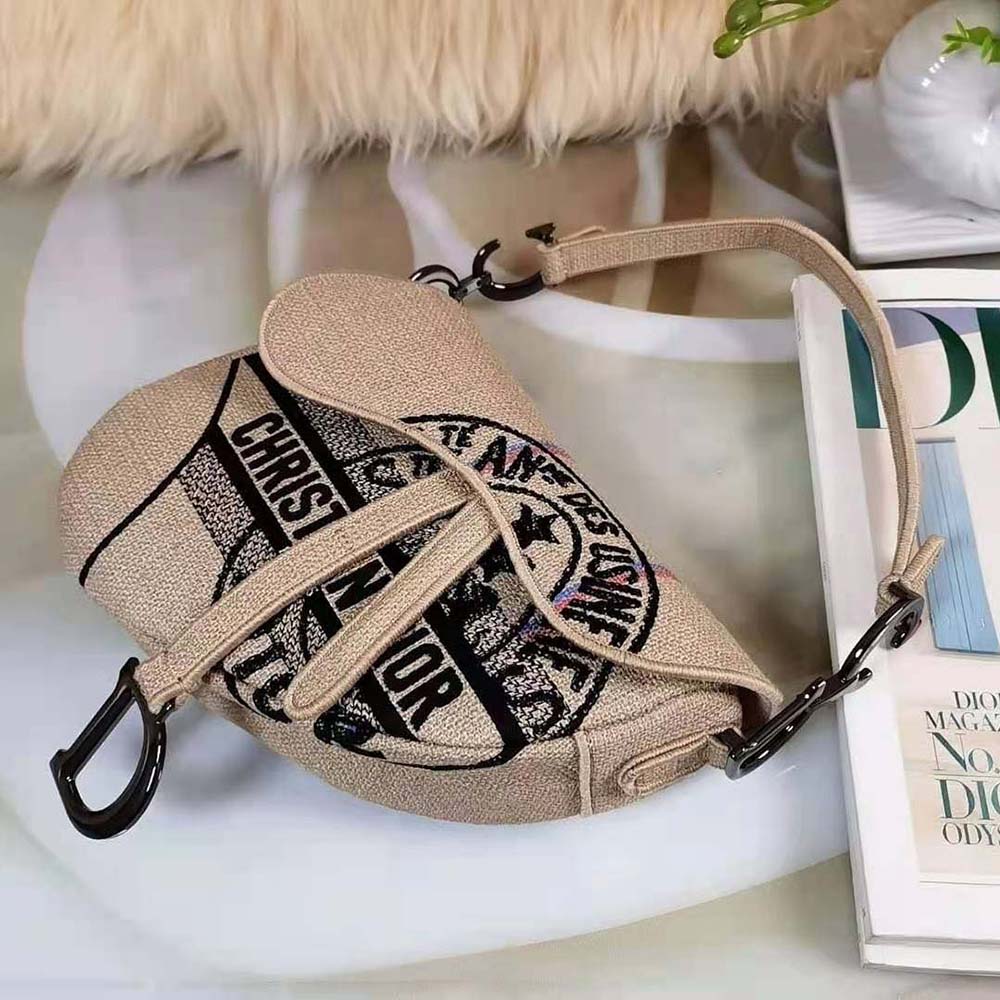 Side angle showing silver hardware and tan strap on Dior Women Saddle Bag Beige Jute Canvas
