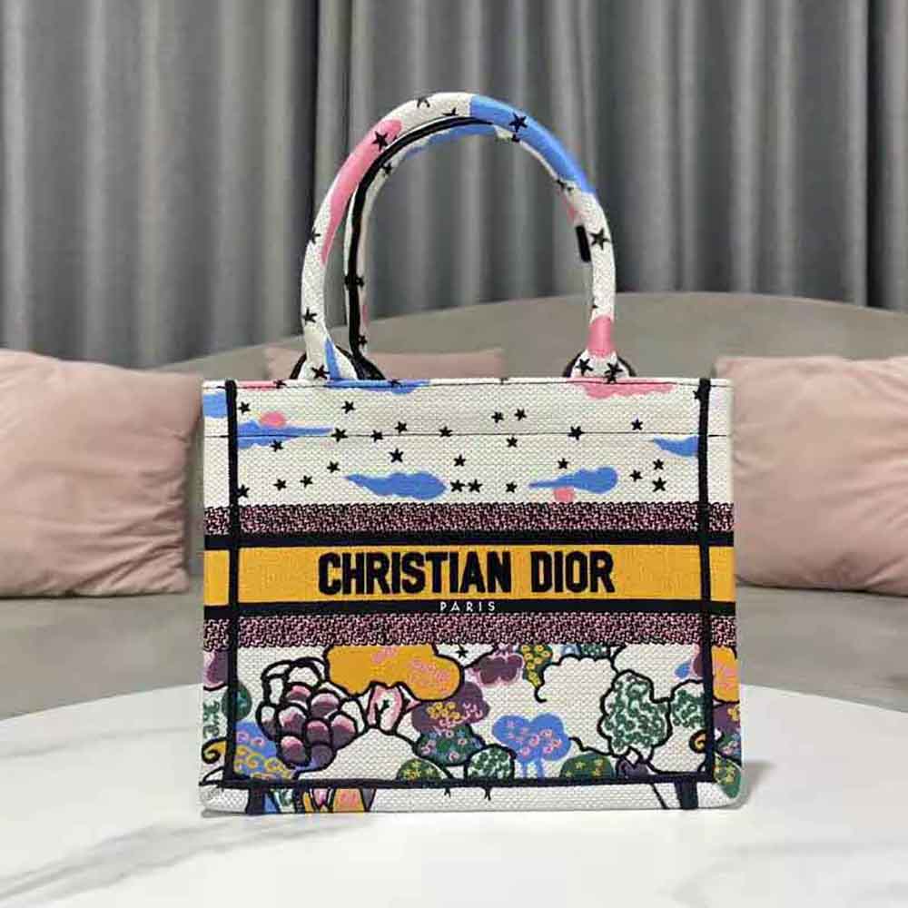 Side angle showing signature hardware on small Dior Women Book Tote in white canvas