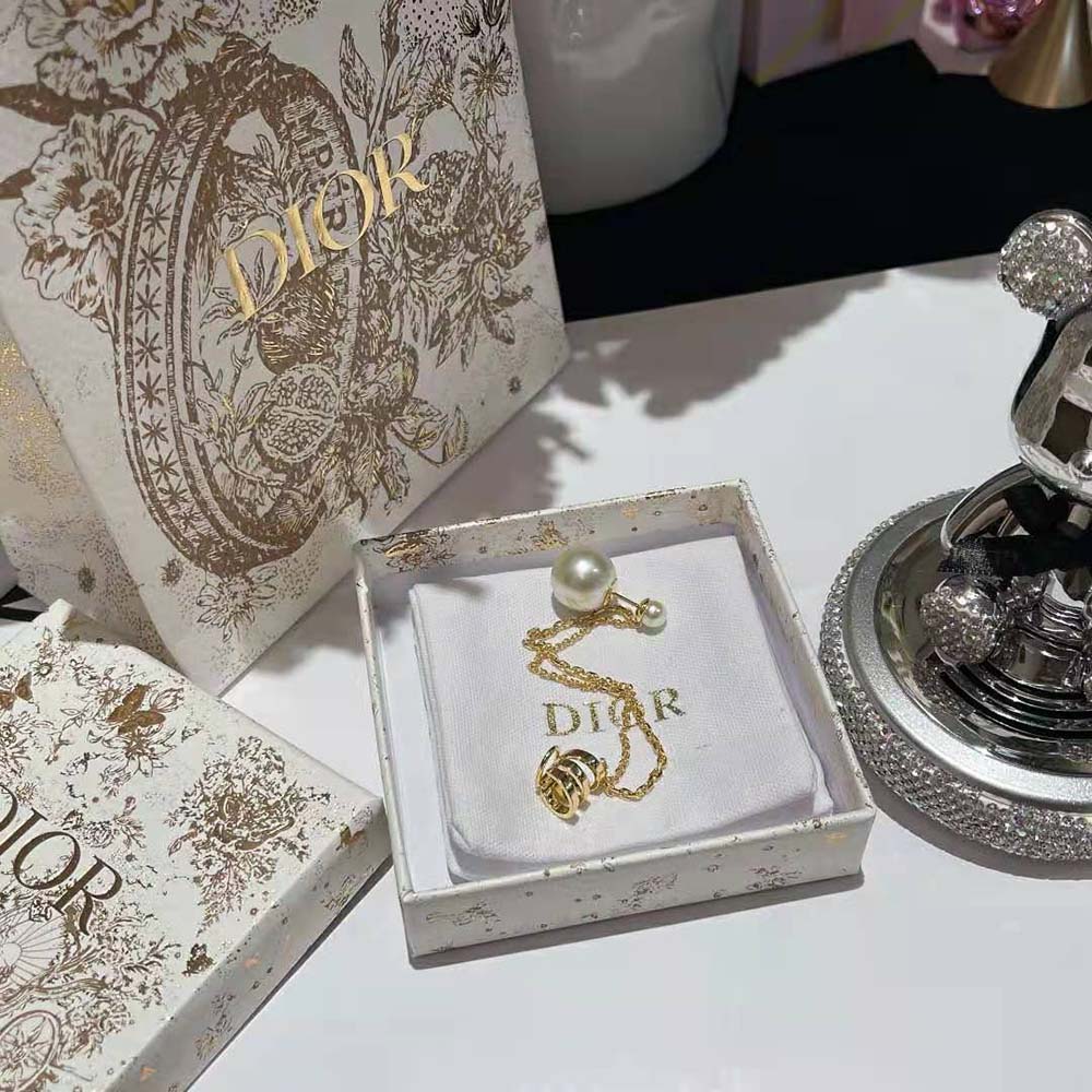 Close-up detail of gold-finish metal and pearl on Dior Women Tribales Earring