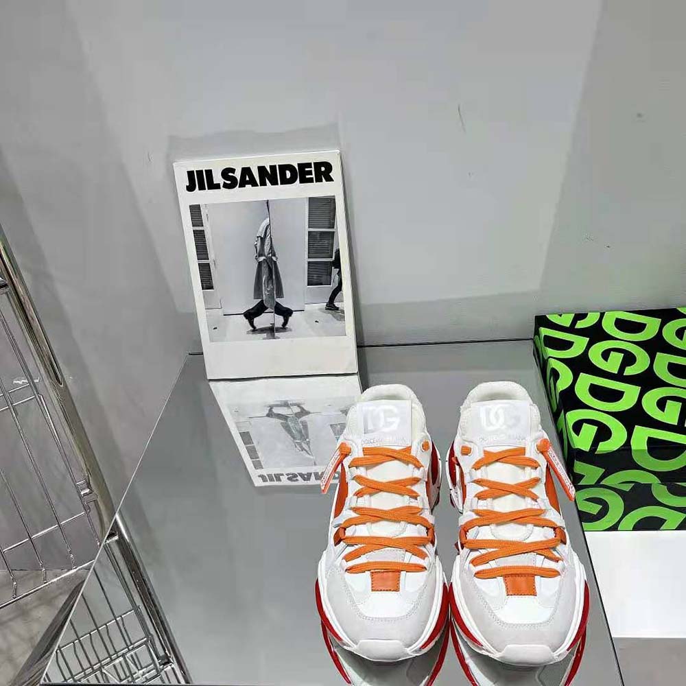 Close-up on vibrant orange leather and mesh details of the sneakers
