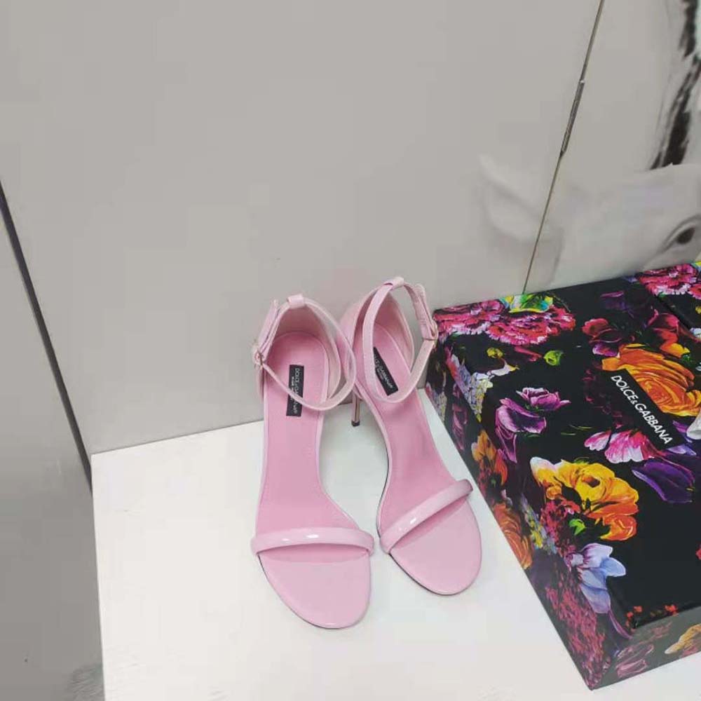 Close-up of gold D&G logo buckle on pink patent leather sandals