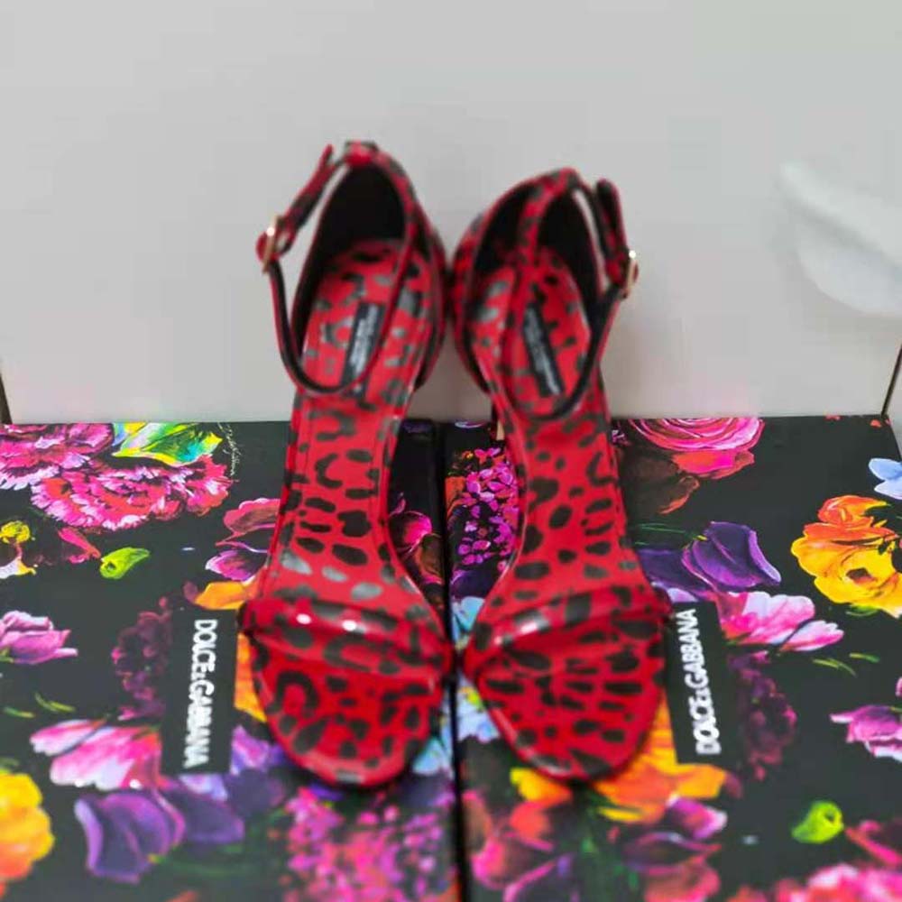 Close-up on D&G logo hardware on red leopard-print patent leather sandals