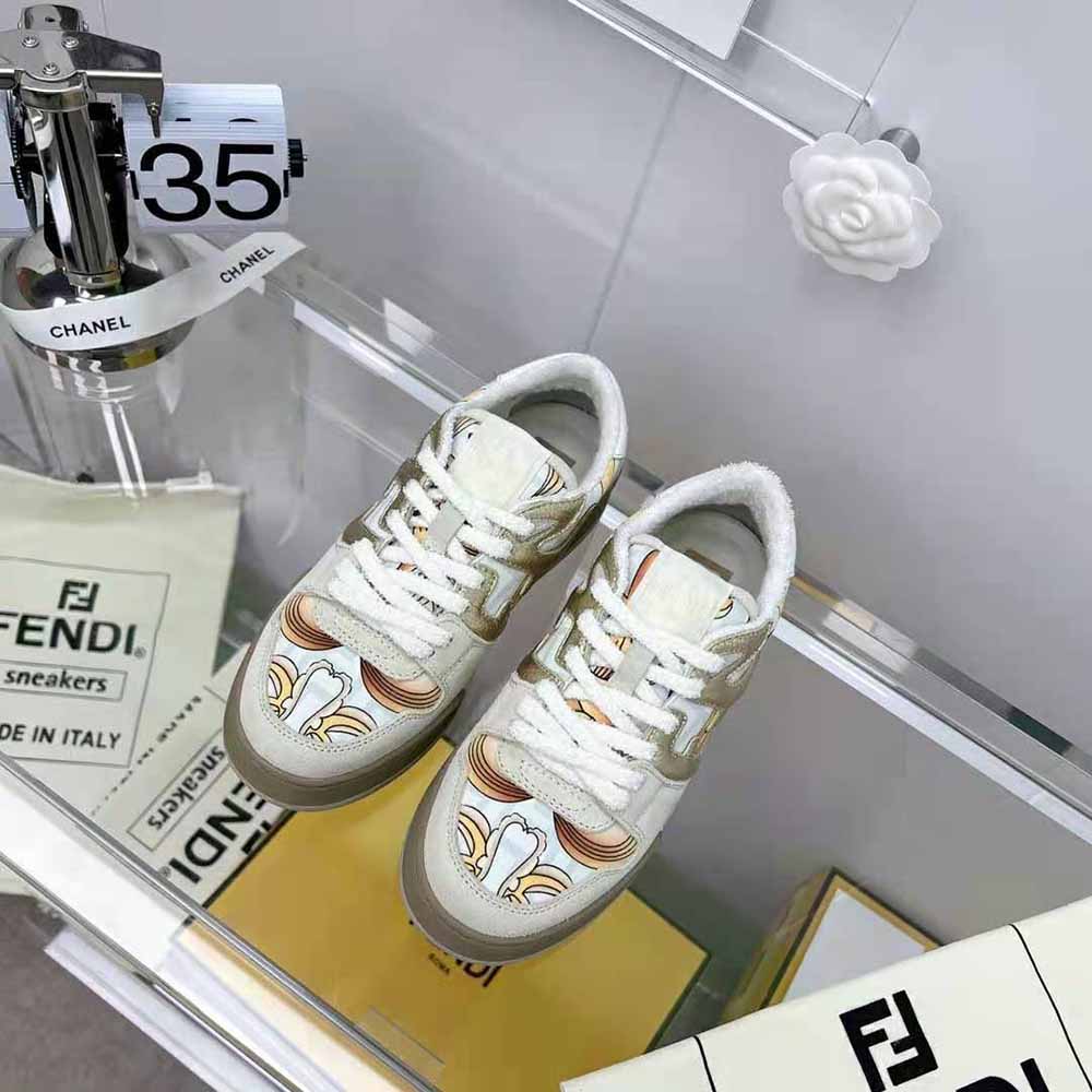 Close-up of beige suede and signature Fendace logo on sneakers