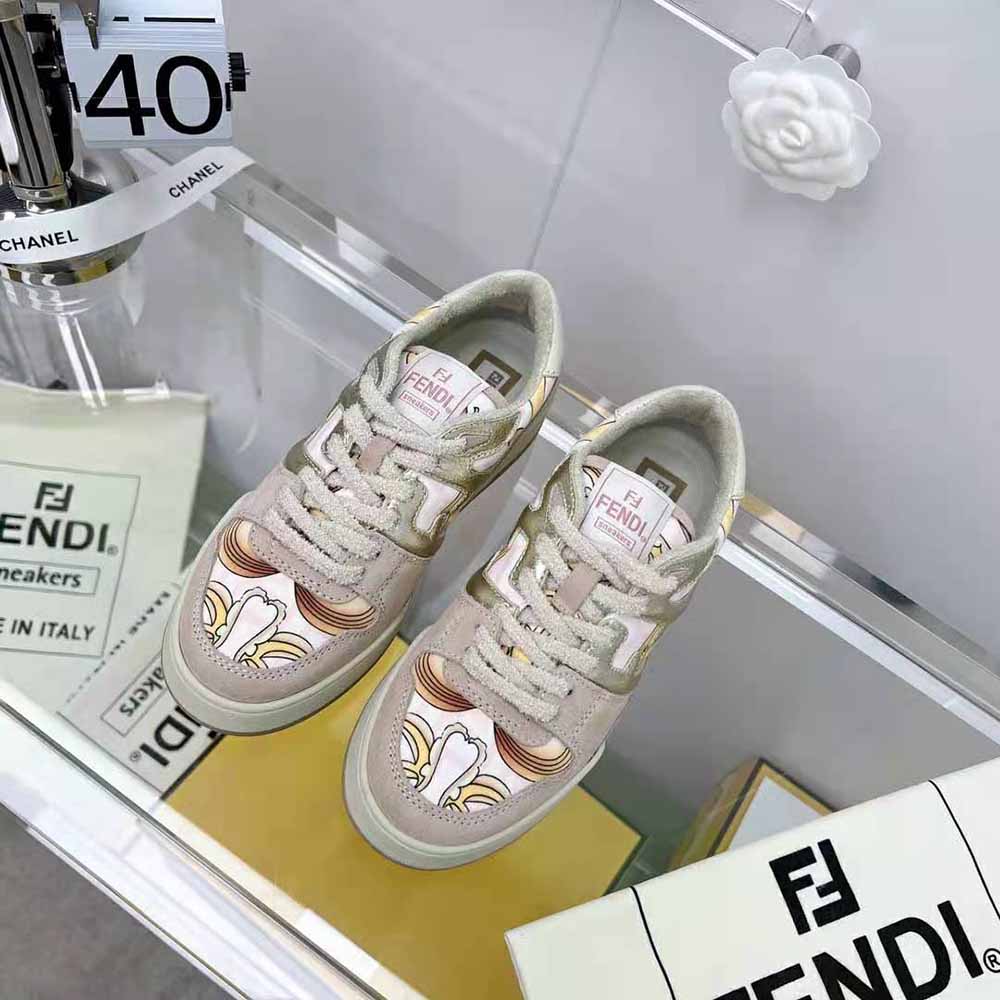 Close-up of gold Fendi logo hardware on pink satin low-tops
